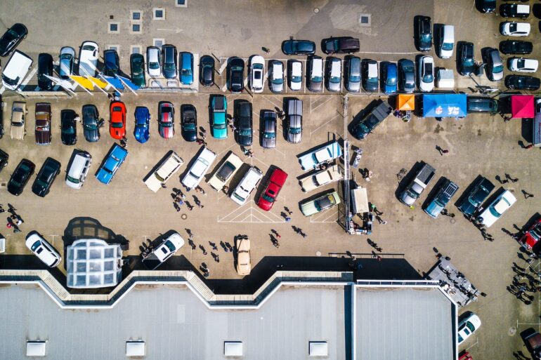 an aerial shot of a dealership with vehicles parked outside where falling used car prices have impacted the market